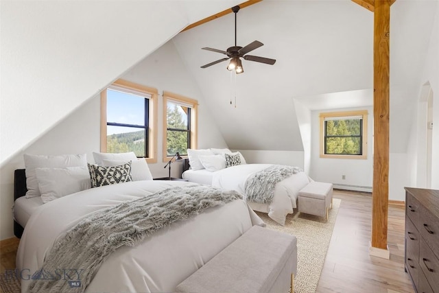 1266 Ousel Falls Rd, Big Sky, MT 59716 - bedroom with multiple windows, vaulted ceiling, light wood-style flooring, a baseboard radiator, and a ceiling fan