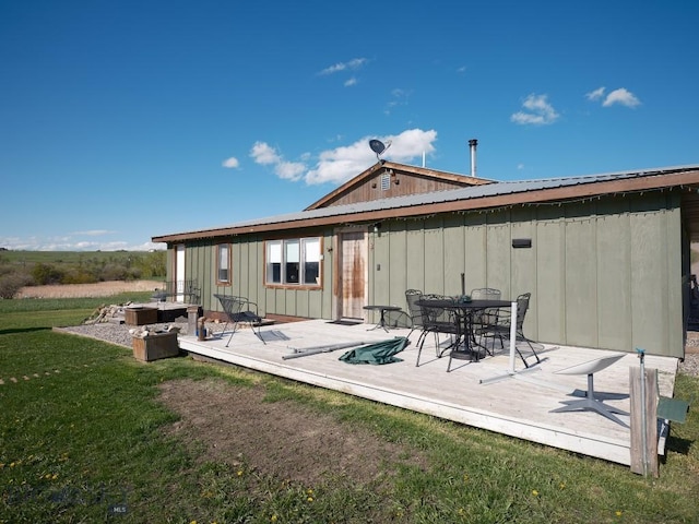 2178 Little Bear Rd, Gallatin Gateway, MT 59730 - rear view of property with a wooden deck, board and batten siding, a yard, outdoor dining area, and metal roof