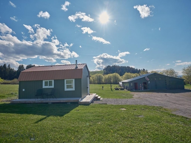 2178 Little Bear Rd, Gallatin Gateway, MT 59730 - view of side of home with an outbuilding, metal roof, a lawn, and a wooden deck
