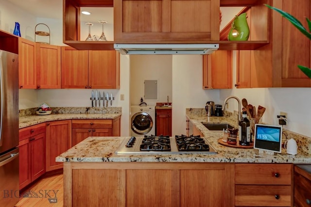 425 N 7th St, Livingston, MT 59047 - kitchen with a sink, appliances with stainless steel finishes, washer / dryer, light wood-style flooring, and light stone countertops