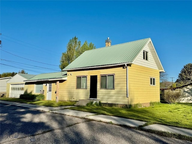15 S Colorado St, Dillon, MT 59725 - view of home's exterior featuring a chimney, metal roof, and a lawn