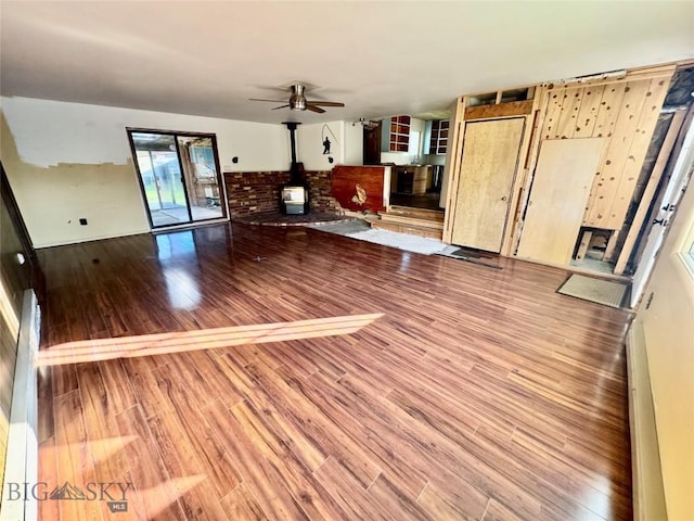15 S Colorado St, Dillon, MT 59725 - unfurnished living room with a wood stove, wood finished floors, and ceiling fan