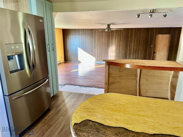 15 S Colorado St, Dillon, MT 59725 - kitchen with stainless steel fridge with ice dispenser, dark wood-type flooring, a ceiling fan, a baseboard heating unit, and wood walls