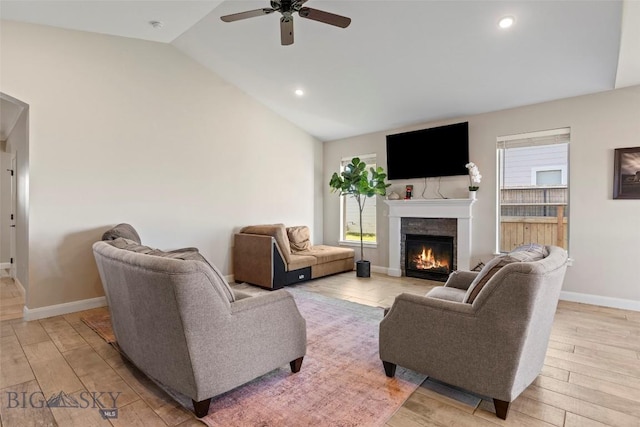 1711 Shelby Ave, Belgrade, MT 59714 - living area featuring lofted ceiling, ceiling fan, a stone fireplace, baseboards, and light wood-type flooring