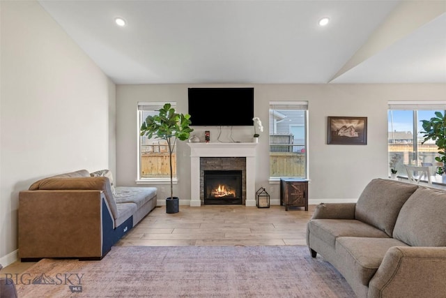 1711 Shelby Ave, Belgrade, MT 59714 - living room featuring a lit fireplace, lofted ceiling, wood finished floors, baseboards, and recessed lighting