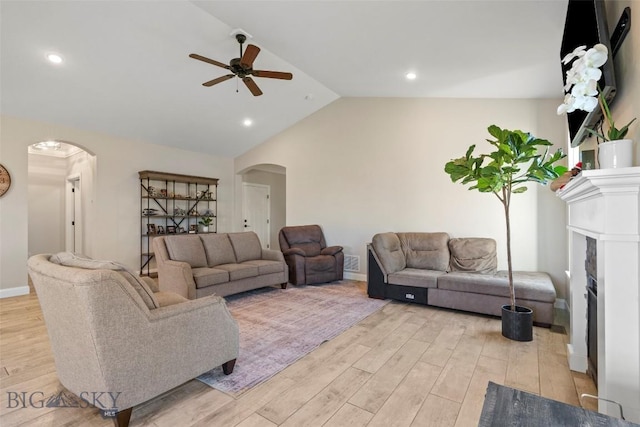 1711 Shelby Ave, Belgrade, MT 59714 - living room featuring arched walkways, a ceiling fan, light wood-style floors, vaulted ceiling, and a fireplace