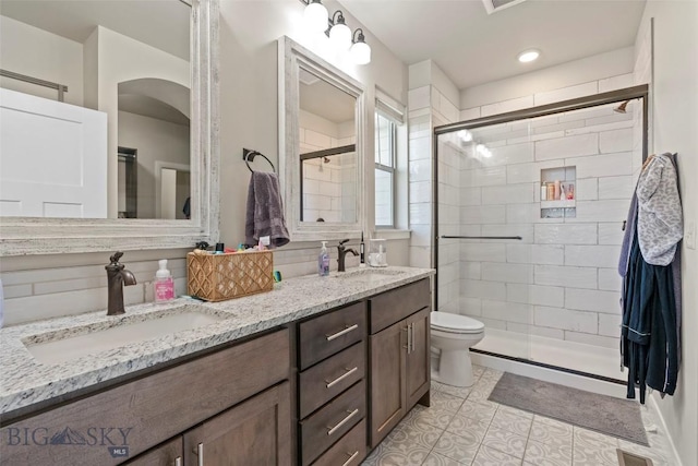 1711 Shelby Ave, Belgrade, MT 59714 - full bath with double vanity, toilet, a stall shower, and tile patterned floors