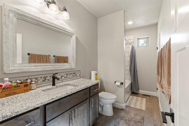 1711 Shelby Ave, Belgrade, MT 59714 - full bath with vanity, toilet, wood finished floors, shower / bathtub combination with curtain, and baseboards