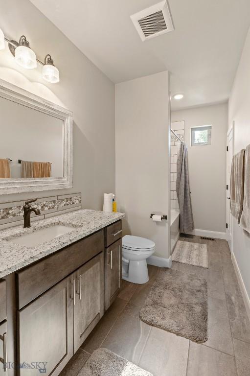 1711 Shelby Ave, Belgrade, MT 59714 - full bath with vanity, toilet, tile patterned floors, and baseboards