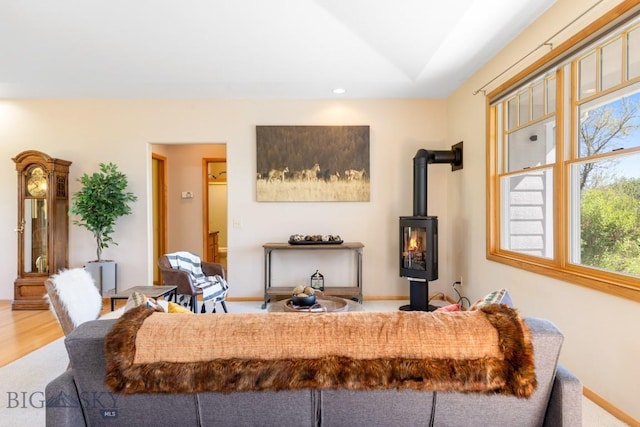 41 Madison, Ennis, MT 59729 - carpeted living room with vaulted ceiling, plenty of natural light, a wood stove, recessed lighting, and baseboards