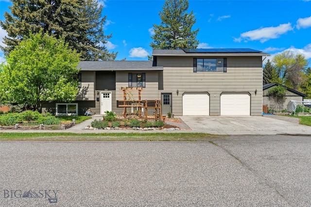 707 Montana St, Belgrade, MT 59714 - view of front of property with roof mounted solar panels, a garage, and driveway