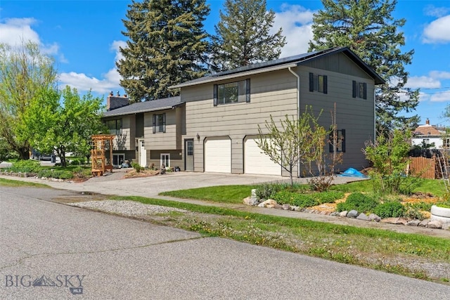 707 Montana St, Belgrade, MT 59714 - view of front facade featuring an attached garage, driveway, and a chimney
