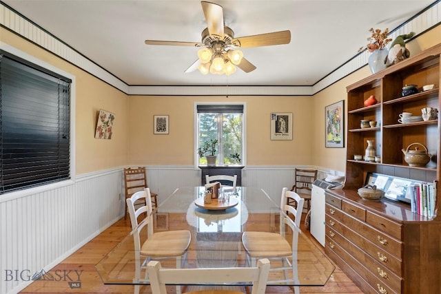 707 Montana St, Belgrade, MT 59714 - dining room featuring light wood-style floors, a wainscoted wall, and a ceiling fan