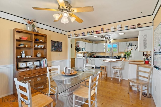 707 Montana St, Belgrade, MT 59714 - dining area with a wainscoted wall, light wood-type flooring, and ceiling fan