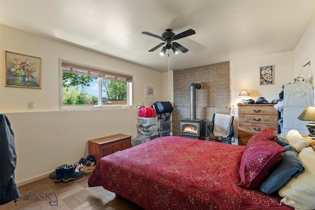 707 Montana St, Belgrade, MT 59714 - carpeted bedroom with a wood stove, a ceiling fan, and baseboards