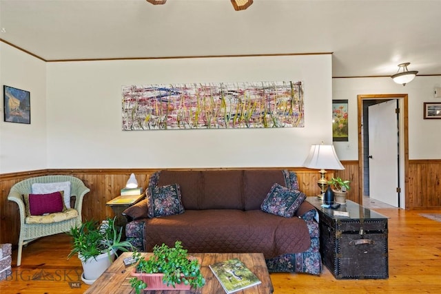 707 Montana St, Belgrade, MT 59714 - living area featuring a wainscoted wall, wooden walls, wood finished floors, and crown molding