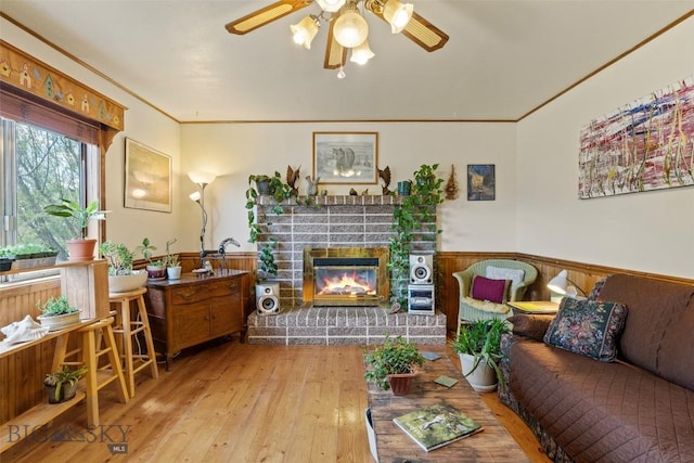 707 Montana St, Belgrade, MT 59714 - living room with crown molding, a wainscoted wall, ceiling fan, a brick fireplace, and hardwood / wood-style flooring