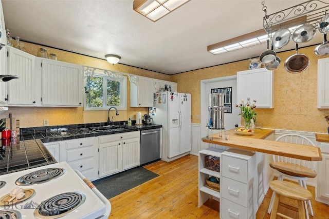 707 Montana St, Belgrade, MT 59714 - kitchen featuring white appliances, light wood-type flooring, a kitchen breakfast bar, white cabinets, and wainscoting