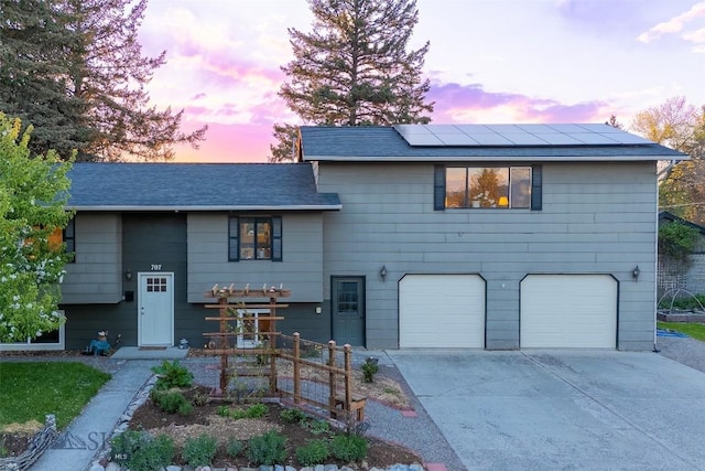 707 Montana St, Belgrade, MT 59714 - view of front of home featuring an attached garage, roof mounted solar panels, driveway, and a shingled roof