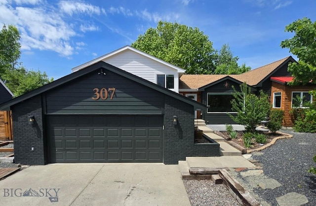 307 Flathead Ave, Bozeman, MT 59718 - view of front facade with concrete driveway, an attached garage, and brick siding