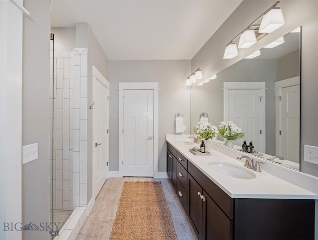 5333 Westmorland Dr, Bozeman, MT 59718 - full bathroom with double vanity, wood finished floors, a tile shower, and baseboards
