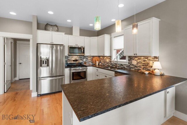 5333 Westmorland Dr, Bozeman, MT 59718 - kitchen with appliances with stainless steel finishes, a sink, dark countertops, and recessed lighting