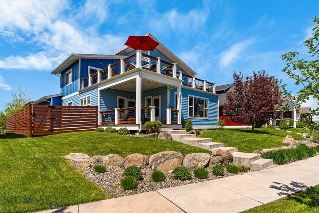 5333 Westmorland Dr, Bozeman, MT 59718 - contemporary house featuring a balcony, board and batten siding, a front lawn, and covered porch