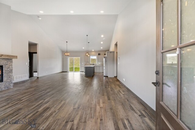 1215 Sweetgrass Ln, Livingston, MT 59047 - unfurnished living room featuring high vaulted ceiling, a fireplace, and dark wood-style floors