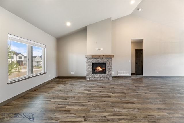 1215 Sweetgrass Ln, Livingston, MT 59047 - unfurnished living room featuring high vaulted ceiling, dark wood finished floors, a stone fireplace, and baseboards