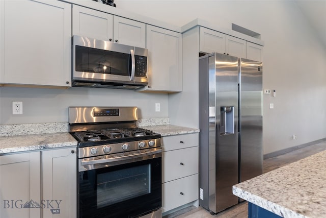 1215 Sweetgrass Ln, Livingston, MT 59047 - kitchen featuring appliances with stainless steel finishes, light wood finished floors, baseboards, and light stone counters