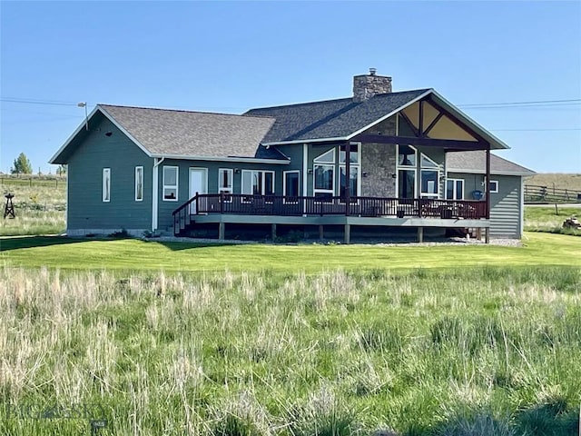 30 Harris Hawk Ct, Dillon, MT 59725 - rear view of property featuring a chimney, a wooden deck, a lawn, and roof with shingles