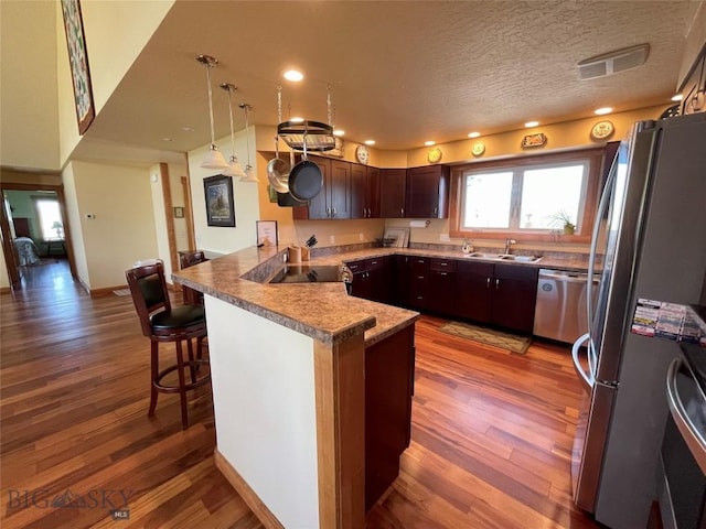 30 Harris Hawk Ct, Dillon, MT 59725 - kitchen featuring stainless steel appliances, a peninsula, a sink, wood finished floors, and recessed lighting