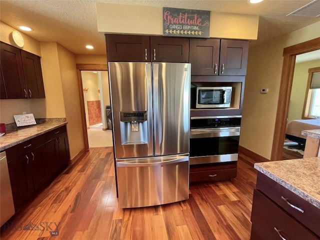 30 Harris Hawk Ct, Dillon, MT 59725 - kitchen featuring appliances with stainless steel finishes, wood finished floors, baseboards, a textured ceiling, and dark brown cabinets