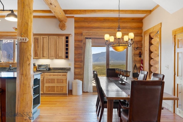 23 Lake Trl, Cameron, MT 59720 - dining room with beam ceiling, a chandelier, light wood-style flooring, log walls, and a mountain view