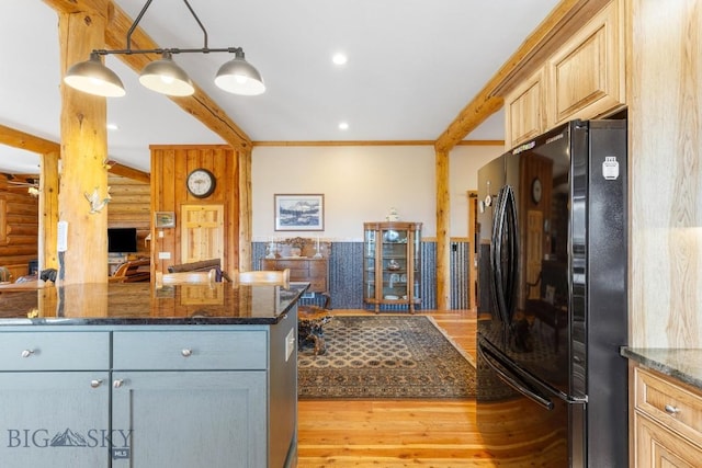 23 Lake Trl, Cameron, MT 59720 - kitchen featuring freestanding refrigerator, wood finished floors, dark stone countertops, beam ceiling, and rustic walls