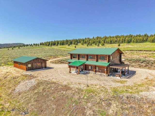 23 Lake Trl, Cameron, MT 59720 - view of front of home with log siding, an outbuilding, a detached garage, and a view of rural / pastoral area