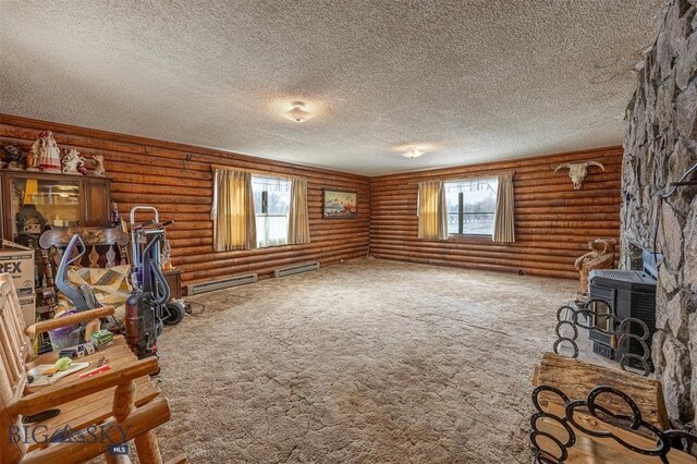 77 First Rd, Whitehall, MT 59759 - unfurnished living room featuring a wood stove, a textured ceiling, a baseboard heating unit, carpet floors, and log walls