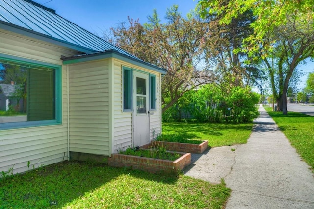 109 N Broadway, Manhattan, MT 59741 - view of side of property featuring a standing seam roof, a lawn, and metal roof