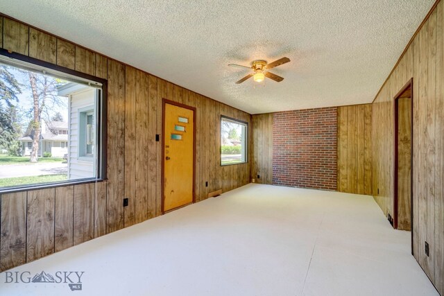 109 N Broadway, Manhattan, MT 59741 - spare room with wooden walls, a textured ceiling, and ceiling fan