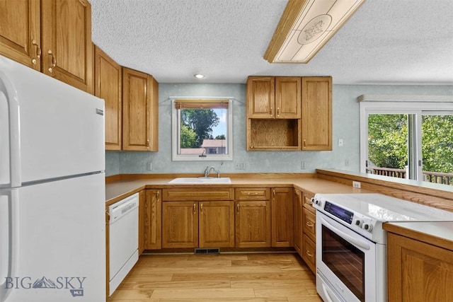 416 Morrow St, Bozeman, MT 59715 - kitchen with white appliances, a textured ceiling, light wood-style flooring, brown cabinets, and recessed lighting