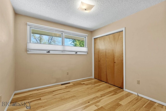 416 Morrow St, Bozeman, MT 59715 - unfurnished bedroom featuring a closet, wood finished floors, a textured ceiling, and baseboards