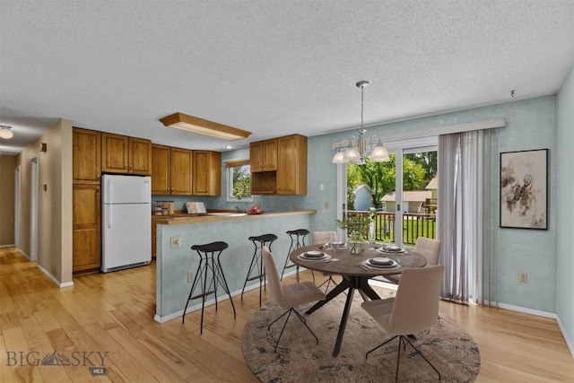 416 Morrow St, Bozeman, MT 59715 - dining room featuring a textured ceiling, light wood-style floors, plenty of natural light, baseboards, and a chandelier
