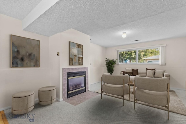 416 Morrow St, Bozeman, MT 59715 - carpeted living room with a textured ceiling, a tiled fireplace, and baseboards