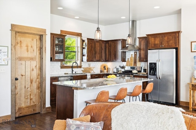 2296 Boylan Rd, Bozeman, MT 59715 - kitchen featuring stainless steel appliances, wall chimney range hood, dark wood finished floors, a kitchen island, and backsplash