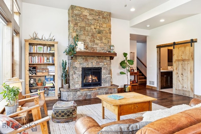 2296 Boylan Rd, Bozeman, MT 59715 - living room with wood finished floors, stairs, a barn door, a stone fireplace, and recessed lighting