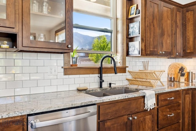 2296 Boylan Rd, Bozeman, MT 59715 - kitchen with dishwasher, a sink, glass insert cabinets, tasteful backsplash, and light stone countertops