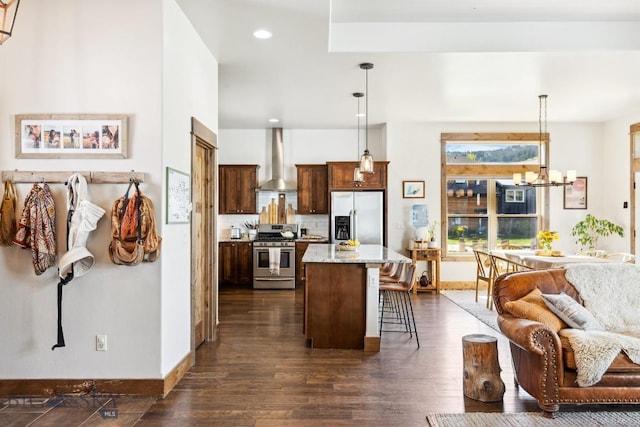 2296 Boylan Rd, Bozeman, MT 59715 - kitchen featuring stainless steel appliances, wall chimney exhaust hood, a kitchen bar, dark wood-style flooring, and open floor plan