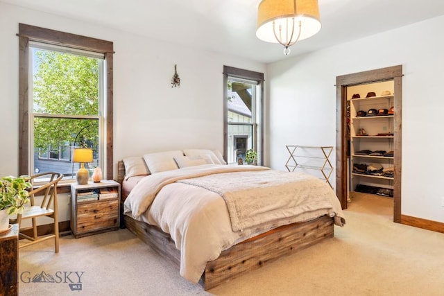 2296 Boylan Rd, Bozeman, MT 59715 - bedroom featuring multiple windows, light colored carpet, and a walk in closet