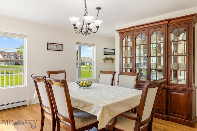 193 Lucille Ln, Bozeman, MT 59718 - dining space with a chandelier, plenty of natural light, light wood-style flooring, and a baseboard heating unit