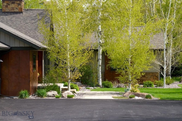 65 Triple Tree Ln, Bozeman, MT 59715 - view of home's exterior featuring a shingled roof, a chimney, and board and batten siding